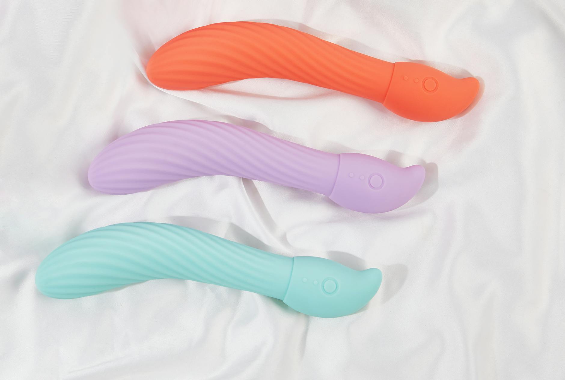 Eine Hand hält einen blauen Lemon Vibrator über einer dekorativen Glasschale und symbolisiert Solo-Vergnügen und Selbstfürsorge.