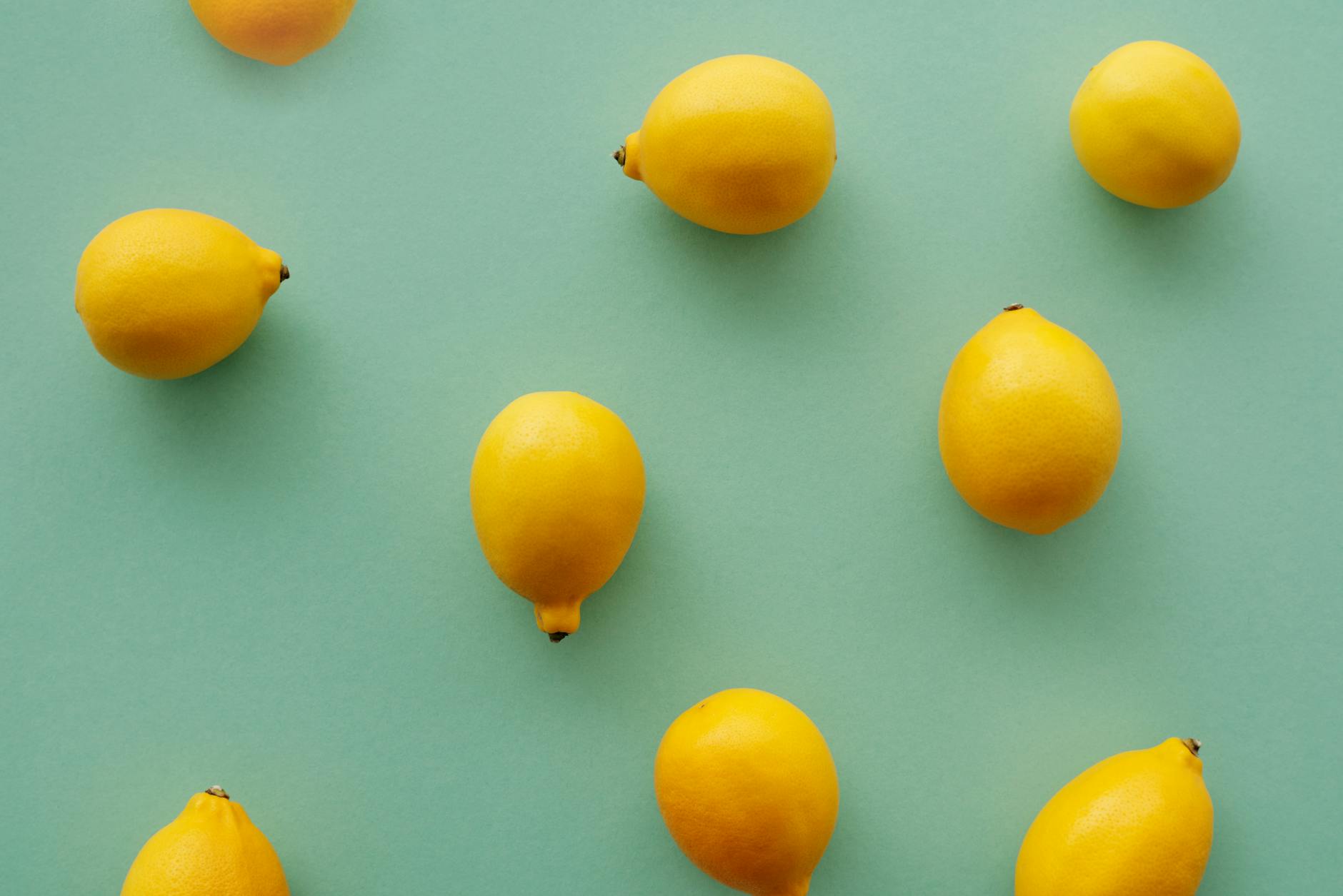 Frau mit Brille hält zwei bunte Lemon Vibratoren vor lila Hintergrund