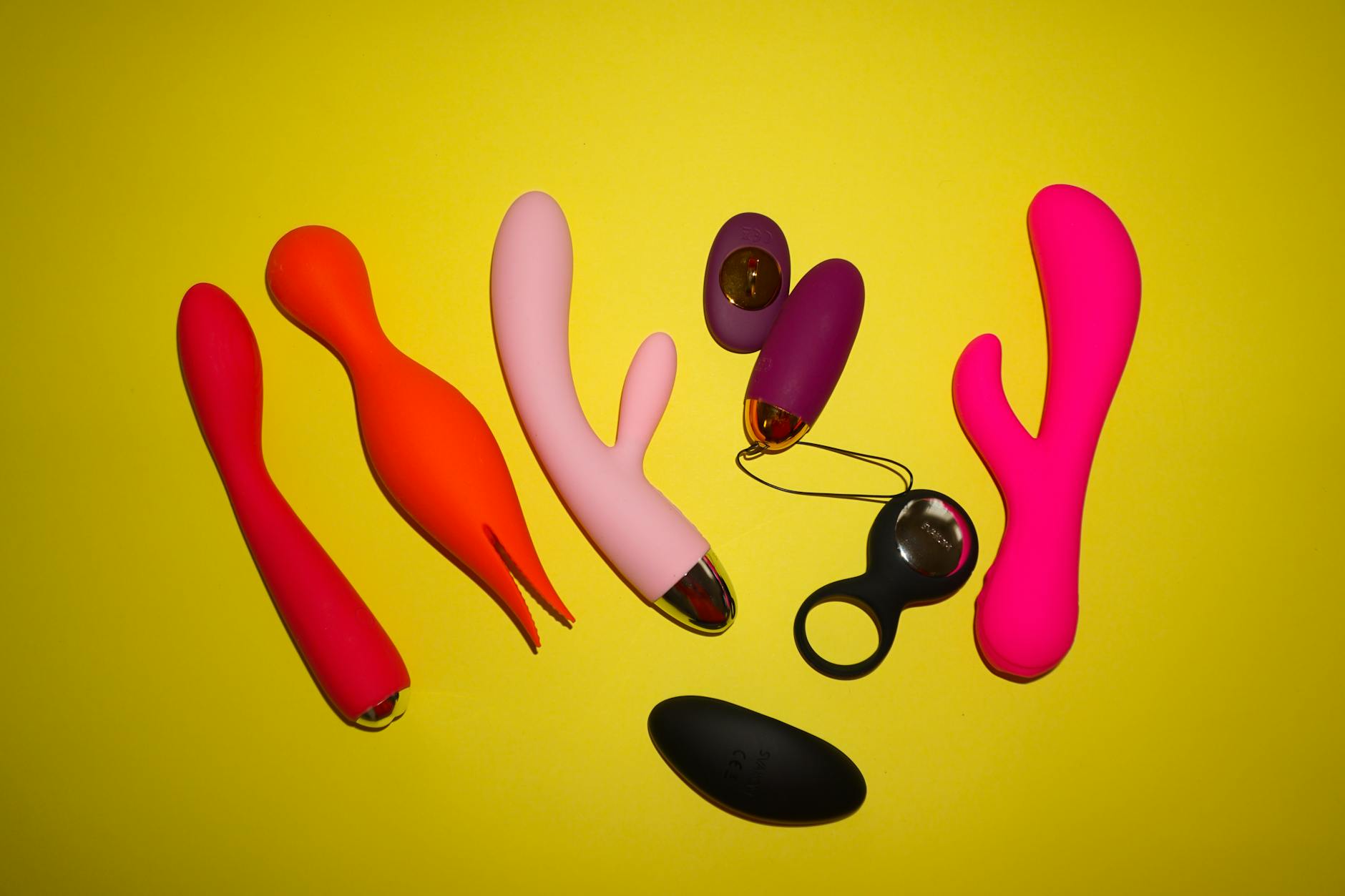Collection of colorful vibrators on a bright yellow background