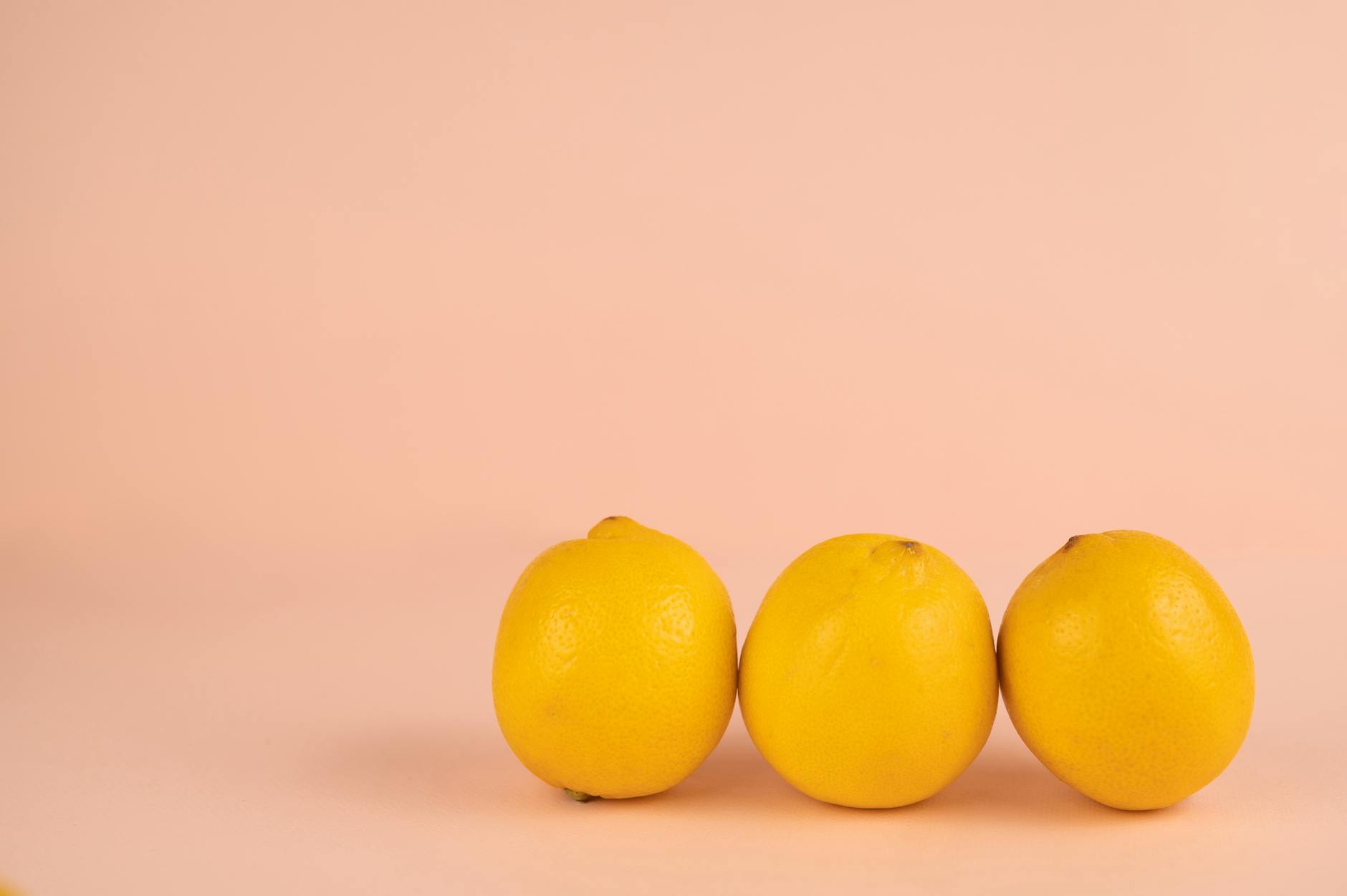Frische gelbe Zitronen auf pastellfarbenem Hintergrund, symbolisierend Neubeginn und Heilung